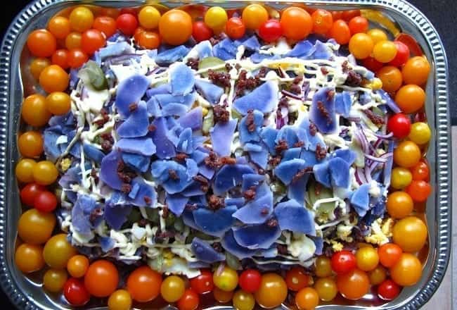 Salade van paarse aardappelen en gele en oranje cherrytomaatjes