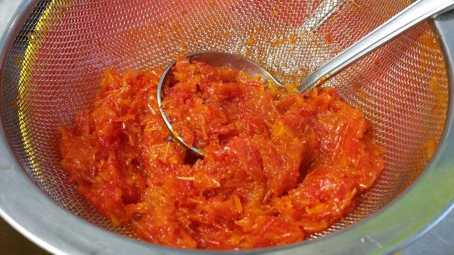De puree door de zeef duwen en de velletjes die achter blijven